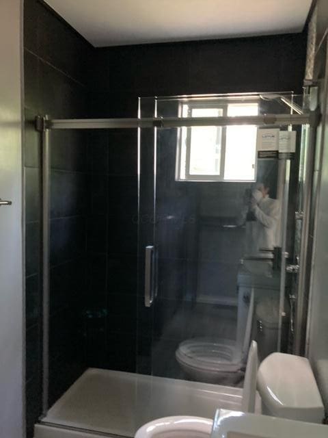 full bath with toilet and a shower stall
