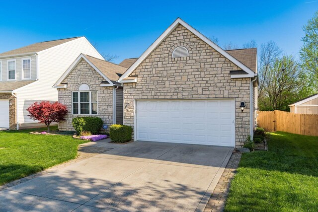 view of front of home with fence, a front lawn, concrete driveway, stone siding, and a garage