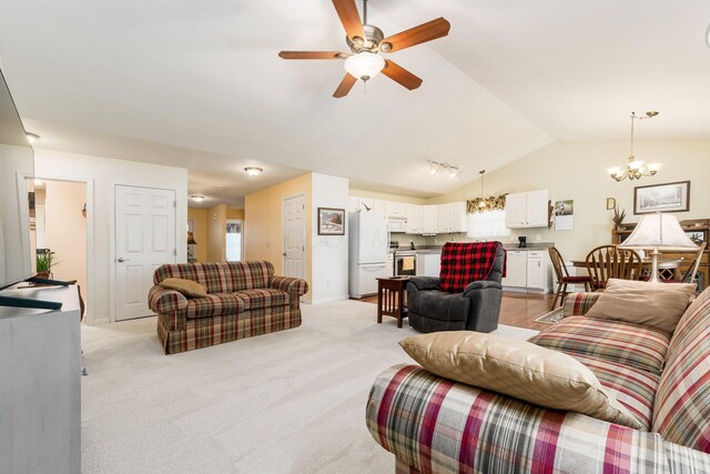 living room with baseboards, lofted ceiling, light carpet, and ceiling fan with notable chandelier
