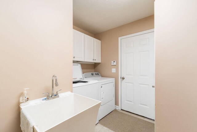 laundry area featuring cabinet space, a sink, light tile patterned flooring, and independent washer and dryer