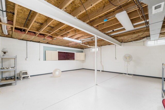 unfinished below grade area featuring concrete block wall and visible vents