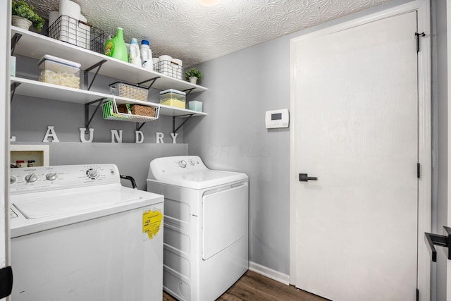 washroom featuring dark wood-style flooring, baseboards, laundry area, and washer and clothes dryer
