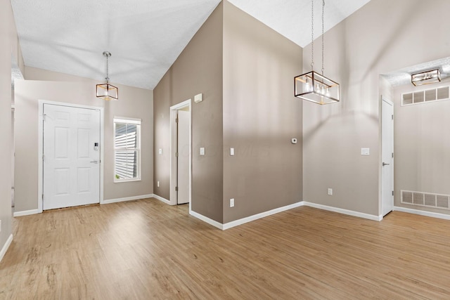 9222 Windy Creek Dr, Columbus, OH 43240 - entrance foyer featuring baseboards, visible vents, light wood-style floors, a chandelier, and lofted ceiling