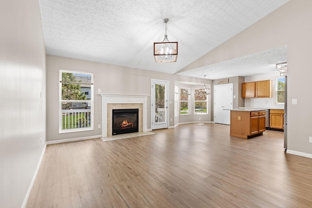 9222 Windy Creek Dr, Columbus, OH 43240 - unfurnished living room with light wood finished floors, baseboards, a textured ceiling, and a chandelier