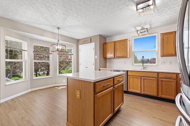 9222 Windy Creek Dr, Columbus, OH 43240 - kitchen featuring brown cabinets, light wood-style floors, stainless steel appliances, and a sink