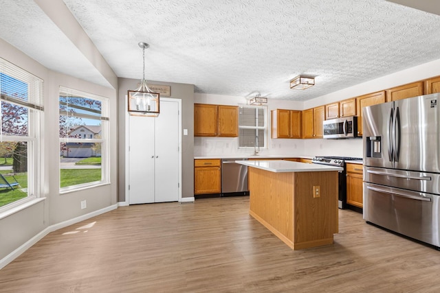 9222 Windy Creek Dr, Columbus, OH 43240 - kitchen featuring a center island, a wealth of natural light, appliances with stainless steel finishes, and light wood finished floors
