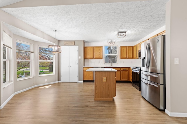 9222 Windy Creek Dr, Columbus, OH 43240 - kitchen featuring light countertops, stainless steel appliances, a kitchen island, and light wood-style floors
