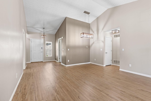 9222 Windy Creek Dr, Columbus, OH 43240 - foyer with high vaulted ceiling, light wood-style floors, visible vents, and baseboards