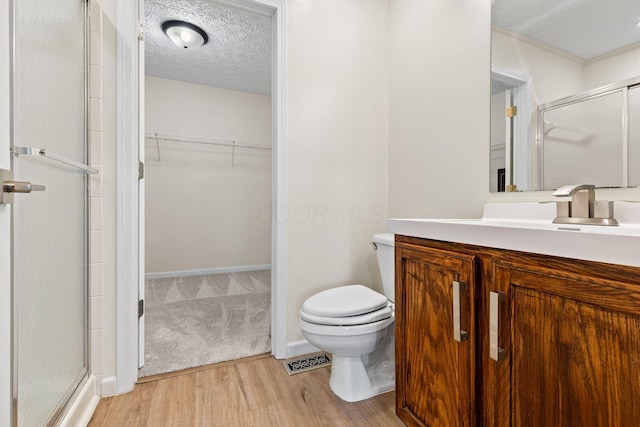 9222 Windy Creek Dr, Columbus, OH 43240 - full bathroom with a shower stall, toilet, a walk in closet, and wood finished floors