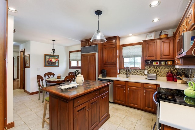 4690 Arrowhead Dr NW, Carroll, OH 43112 - kitchen with stainless steel appliances, a sink, light tile patterned floors, tasteful backsplash, and pendant lighting