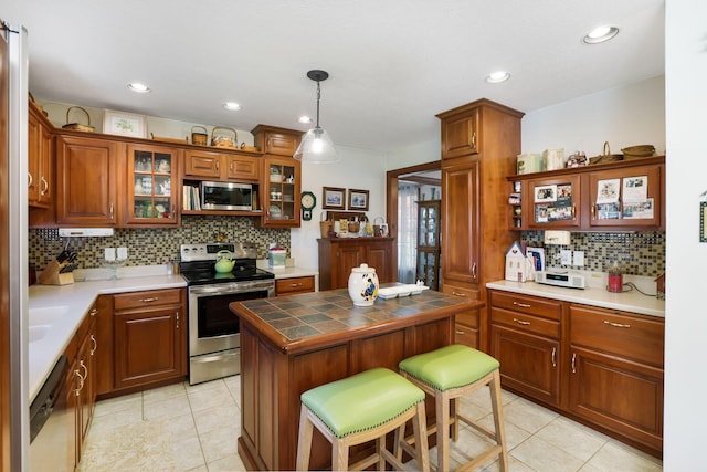 4690 Arrowhead Dr NW, Carroll, OH 43112 - kitchen featuring stainless steel appliances, backsplash, light tile patterned floors, tile countertops, and glass insert cabinets