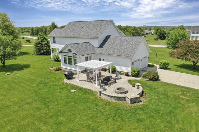 4690 Arrowhead Dr NW, Carroll, OH 43112 - back of property with a fire pit, a lawn, a garage, roof with shingles, and a patio area
