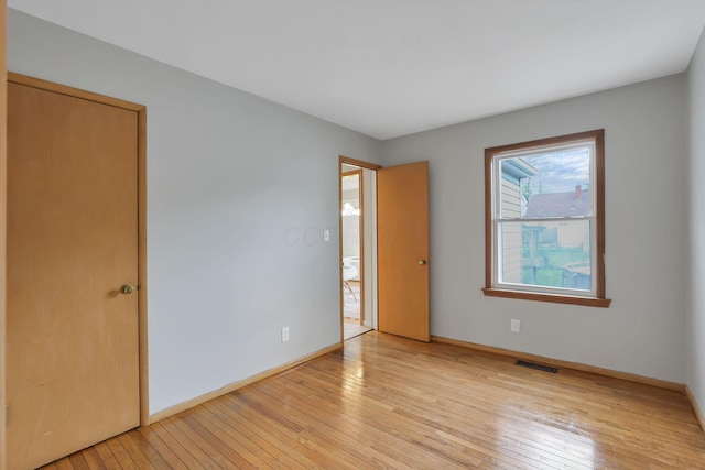 unfurnished bedroom featuring visible vents, light wood finished floors, and baseboards