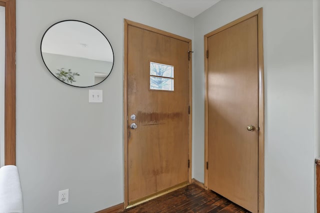 entrance foyer with dark wood-style flooring and baseboards