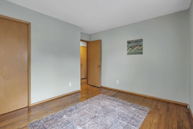 unfurnished bedroom with baseboards and wood finished floors