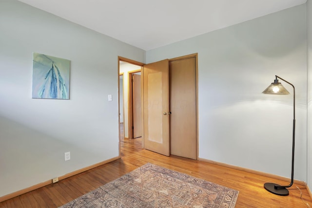 unfurnished bedroom with baseboards and light wood-type flooring