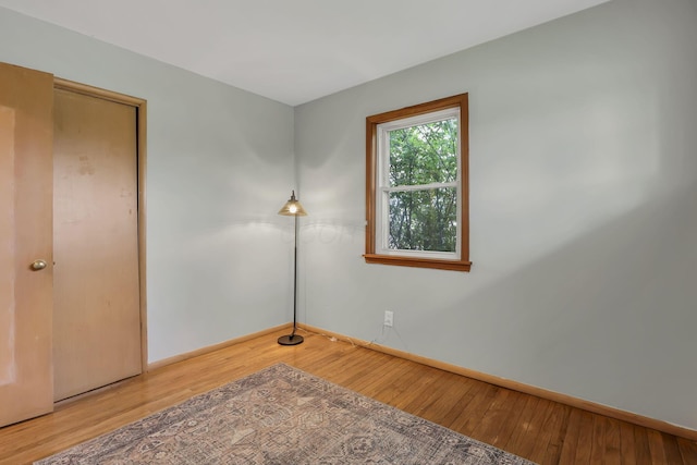 unfurnished bedroom with baseboards and wood-type flooring