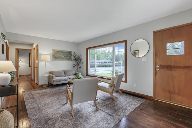 living area featuring baseboards, plenty of natural light, and hardwood / wood-style floors