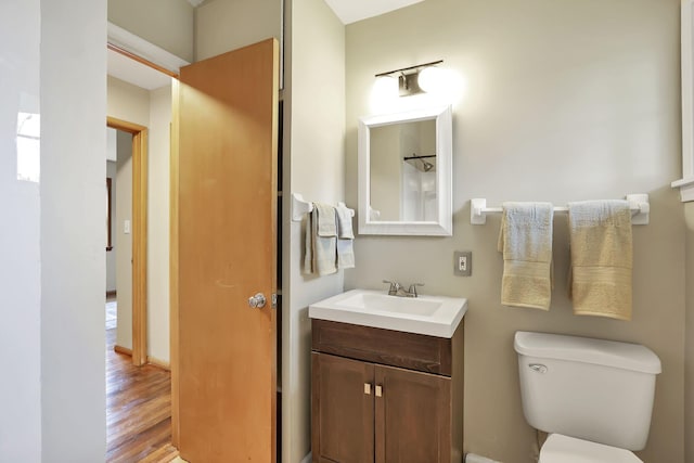 bathroom with toilet, wood finished floors, and vanity