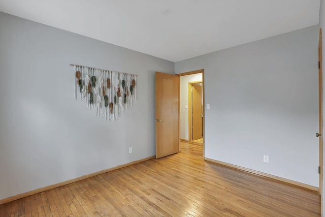 unfurnished room featuring baseboards and light wood-style flooring