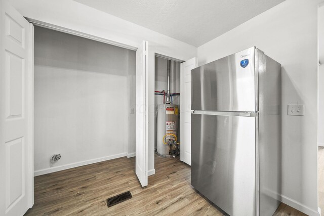 2728 Hiawatha St, Columbus, OH 43211 - interior space with freestanding refrigerator, gas water heater, wood finished floors, and baseboards