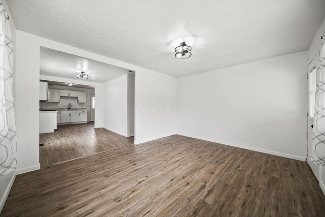 2728 Hiawatha St, Columbus, OH 43211 - unfurnished living room featuring dark wood finished floors, a sink, and baseboards