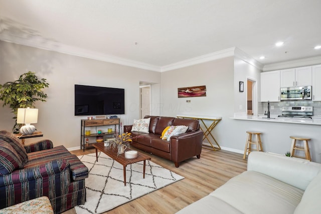 living room featuring recessed lighting, baseboards, ornamental molding, and light wood-type flooring
