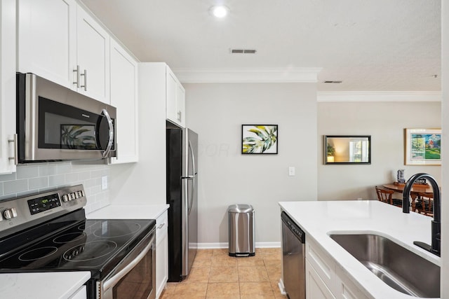 kitchen featuring visible vents, ornamental molding, a sink, appliances with stainless steel finishes, and backsplash