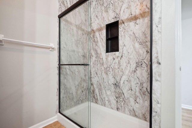 bathroom featuring baseboards and a stall shower