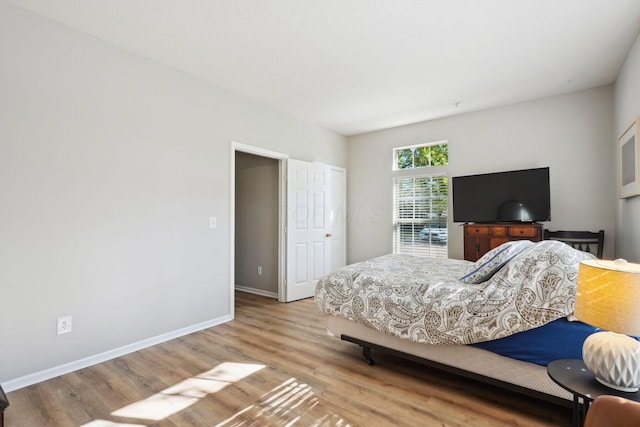 bedroom featuring baseboards and wood finished floors