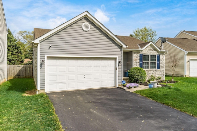 view of front of home featuring a garage, stone siding, a front yard, and aphalt driveway