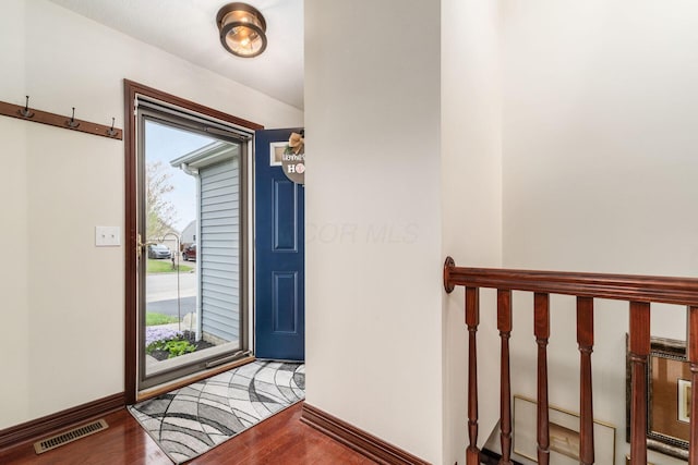 entryway with wood finished floors, visible vents, and baseboards