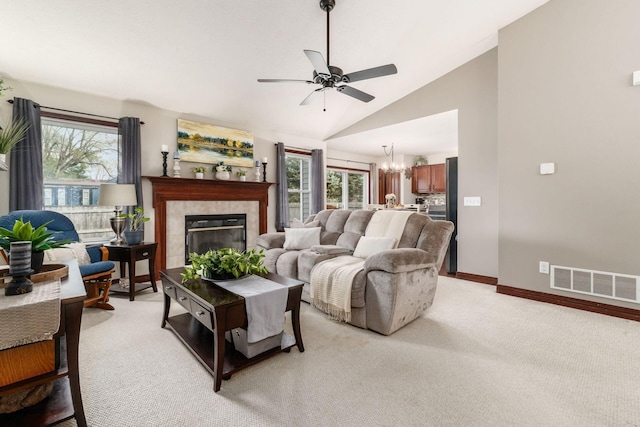 living room featuring ceiling fan with notable chandelier, visible vents, light colored carpet, and a healthy amount of sunlight