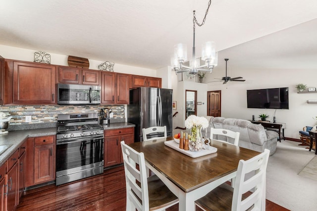 kitchen with ceiling fan with notable chandelier, open floor plan, stainless steel appliances, decorative light fixtures, and backsplash
