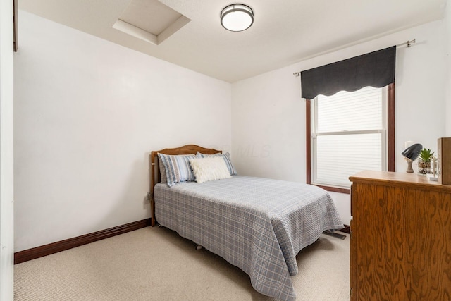 bedroom featuring light colored carpet, baseboards, and attic access