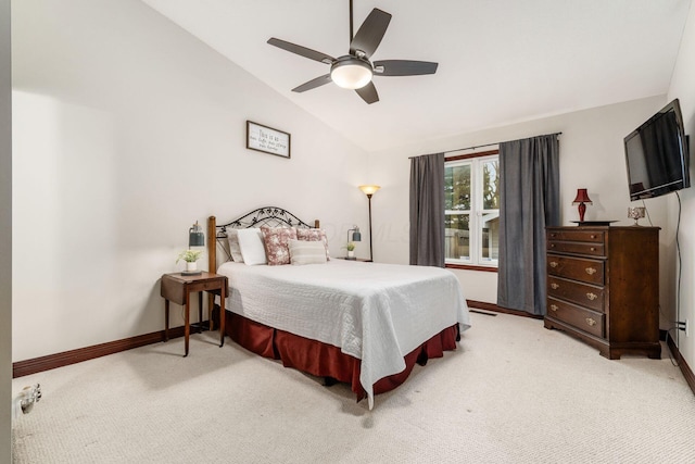 bedroom featuring lofted ceiling, light carpet, baseboards, and ceiling fan
