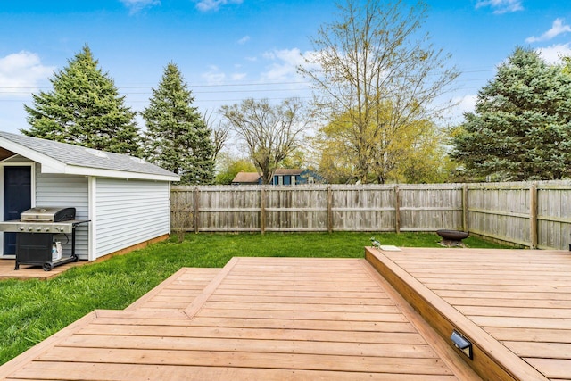 wooden terrace featuring a storage shed, a fenced backyard, an outdoor structure, a grill, and a yard