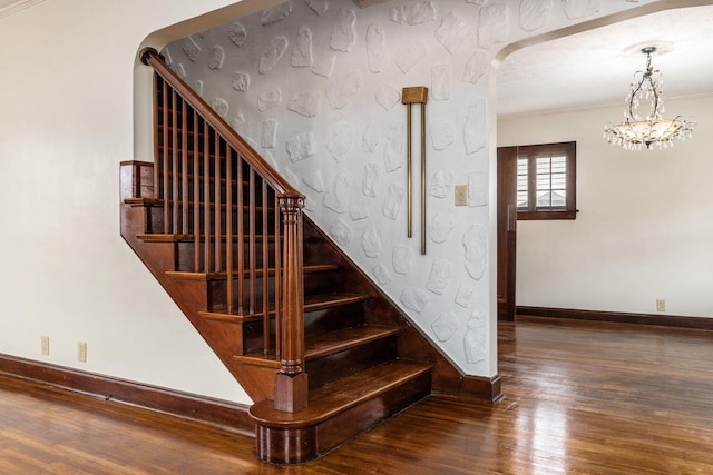 629 Hilltonia Ave, Columbus, OH 43223 - stairway featuring a notable chandelier, wood finished floors, arched walkways, baseboards, and ornamental molding