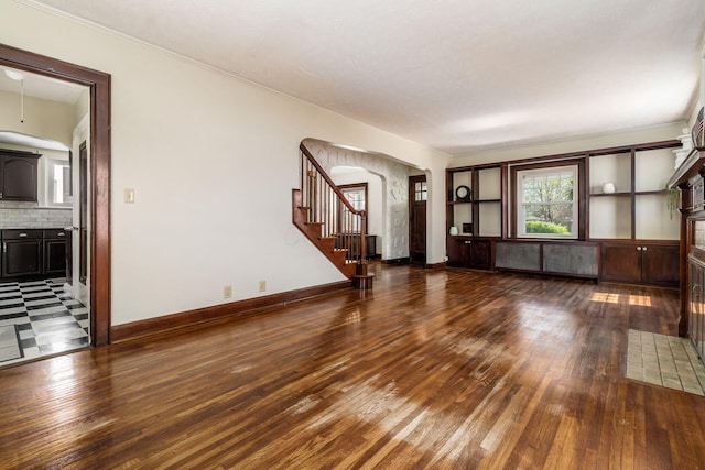 629 Hilltonia Ave, Columbus, OH 43223 - unfurnished living room with crown molding, arched walkways, stairway, and wood-type flooring