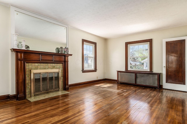 629 Hilltonia Ave, Columbus, OH 43223 - unfurnished living room with a tiled fireplace, baseboards, ornamental molding, and wood-type flooring