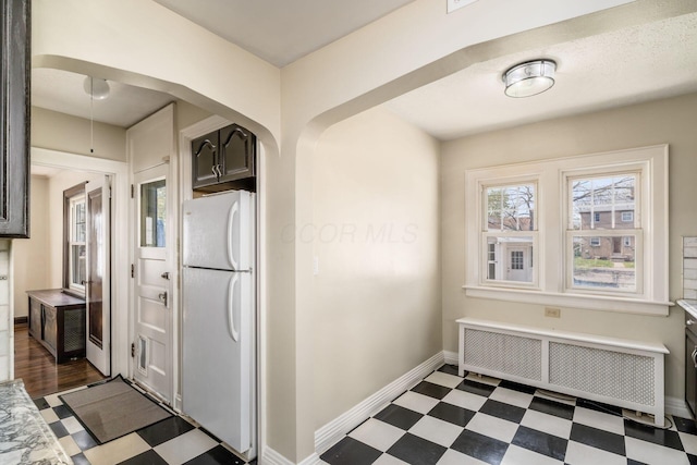 629 Hilltonia Ave, Columbus, OH 43223 - kitchen featuring baseboards, radiator heating unit, dark floors, and freestanding refrigerator