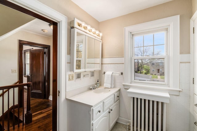 629 Hilltonia Ave, Columbus, OH 43223 - bathroom featuring wood finished floors, wainscoting, vanity, tile walls, and ornamental molding
