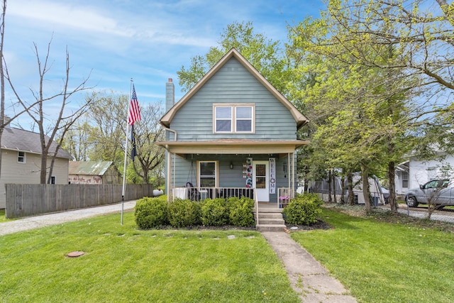 bungalow with a porch, a front lawn, fence, and a chimney