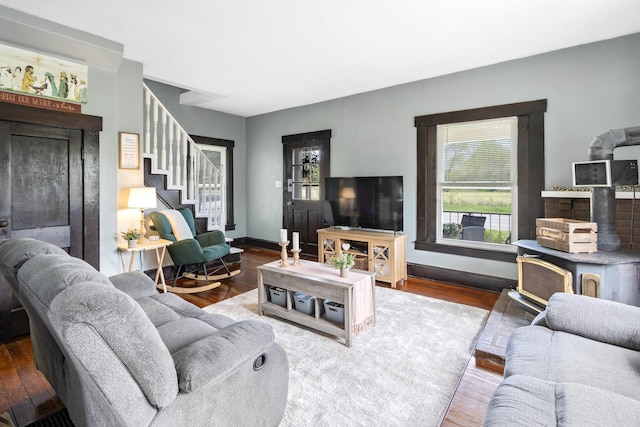 living area featuring baseboards, stairs, and wood finished floors