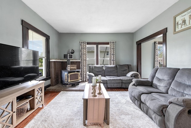 living room featuring a wood stove and wood finished floors