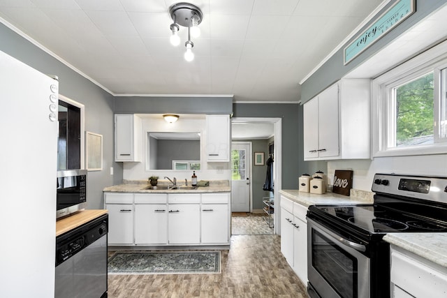 kitchen with a sink, light countertops, stainless steel appliances, and light wood-type flooring