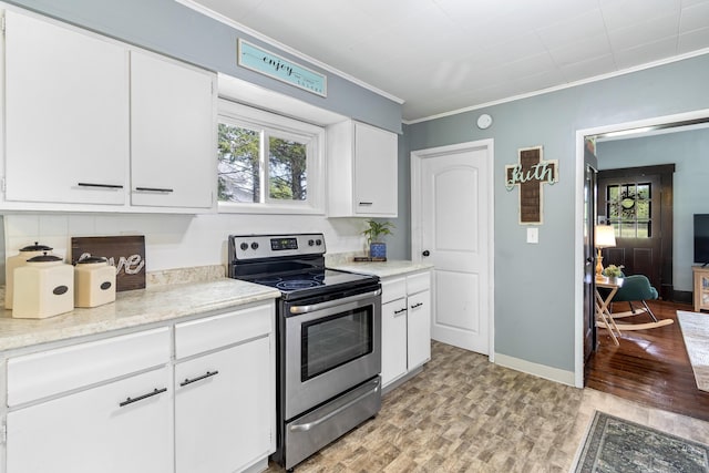kitchen with stainless steel electric stove, ornamental molding, plenty of natural light, and light wood finished floors