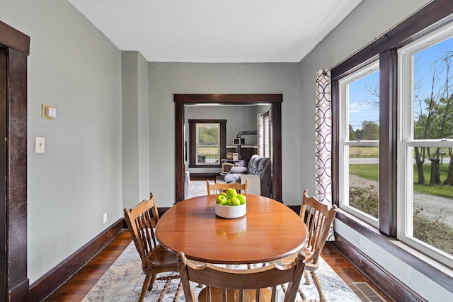 dining area with baseboards, dark wood finished floors, and a wealth of natural light