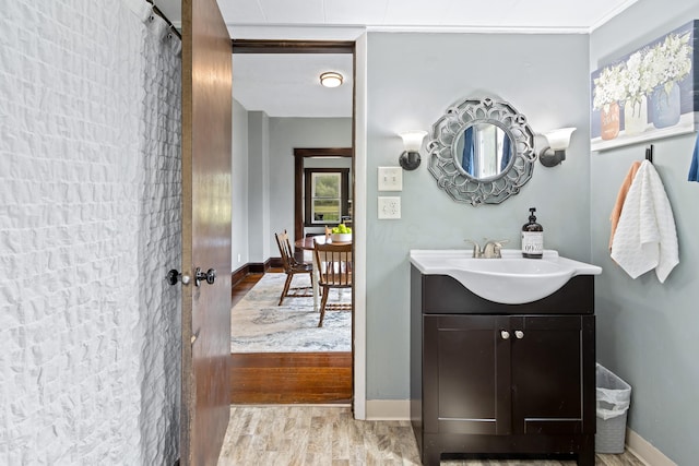 bathroom featuring baseboards, wood finished floors, and vanity