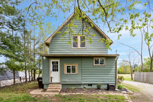 back of property with fence, central AC unit, entry steps, and crawl space